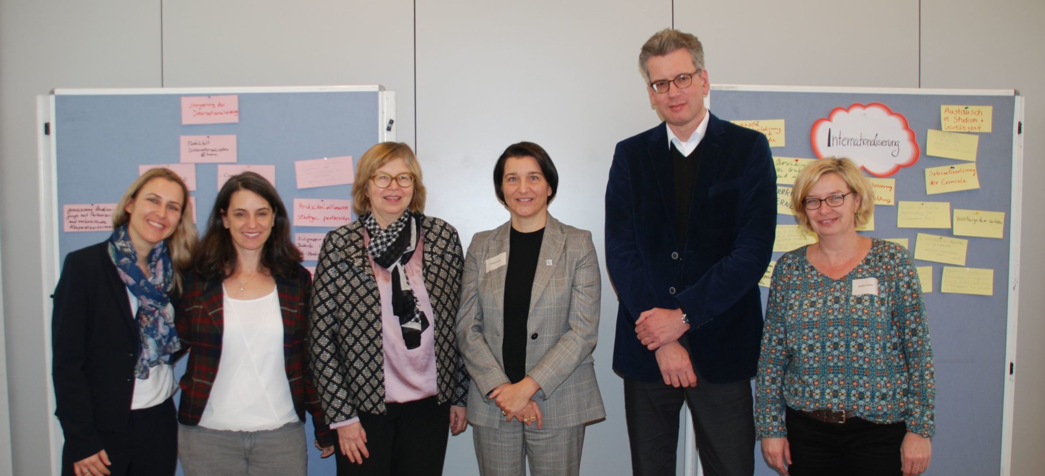 Thementag Internationalisierung Gruppenfoto der Organisatorinnen und Referent*innen vor Stellwand mit Präsentation der Ergebnisse
